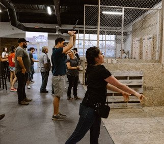 A girl and others throwing axes
